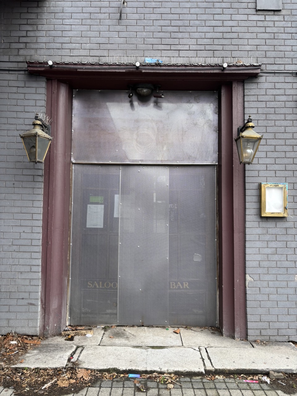 Photograph of a closed pub with security shutters
